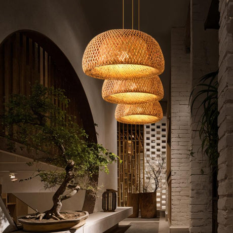 Shades lit in a row beside an arched doorway with a bonsai on a stone ledge