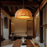 One shade lit above a long low table in a room with wood screens and a bench