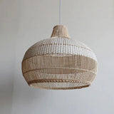Close view of the woven rattan bell against a pale wall