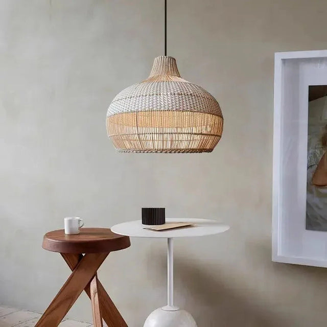 Woven rattan bell shade above a small side table